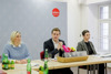 Dr.in Sabine Naderer-Jelinek, Landesrat Stefan Kaineder und DIin Daniela König, MBA, sitzen nebeneinander an einem Konferenztisch