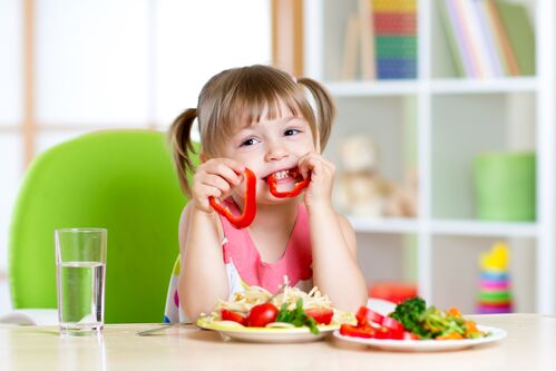 kleines Mädchen isst Gemüse 