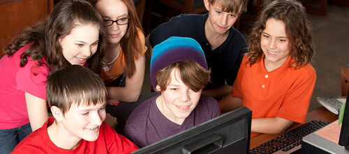 Jugendliche vor Computerbildschirm.
