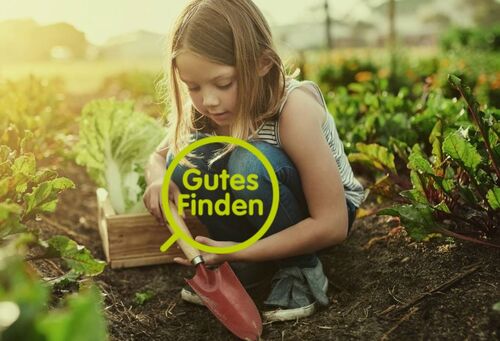 Sujet „Gutes Finden“-App, Mädchen mit Gartenschaufel vor Beet mit Salaten und Rübenpflanzen.