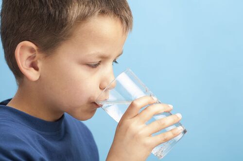 Kind trinkt ein Glas Wasser