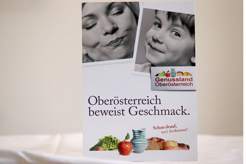 Plakat mit Gesichter von einer Frau und einem Jungen und dem Text: Genussland Oberösterreich - Oberösterreich beweist Geschmack, Schau drauf, wo’s herkommt!