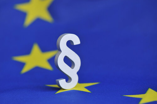 Paragraph-Symbol steht auf einer EU-Flagge 