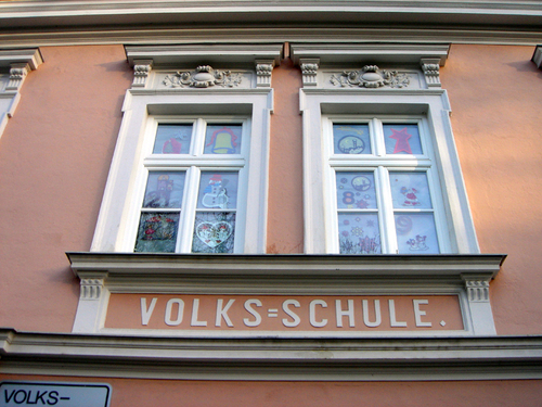 Schriftzug "Volksschule" an einer Hausmauer 
