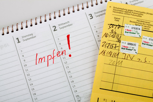 Impfpass und ein Kalender wo ein Impftermin eingetragen ist.