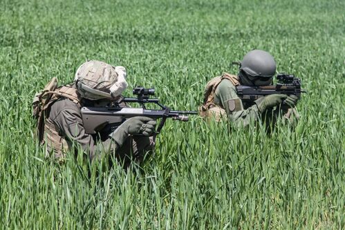 zwei Soldaten in Deckung mit einem Sturmgewehr im Anschlag