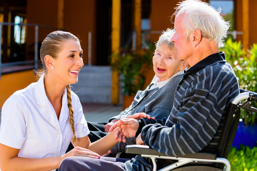 Krankenpflegerin mit einem älteren Herr und einer älteren Dame