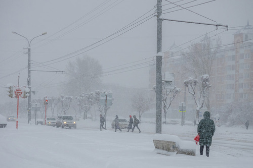 Straße mit Autos und Fußgängern im Winter 