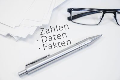Symbolbild mit einer Brille und Kugelschreiber