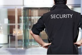 Ein Mann mit schwarzer Security Jacke