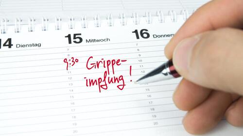 Kalenderblatt mit roter Aufschrift Grippeimpfung Kalenderblatt mit roter Aufschrift Grippeimpfung