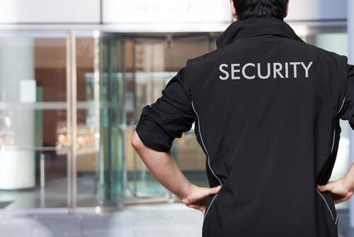 Mann mit schwarzer Security-Jacke im Eingangsbereich