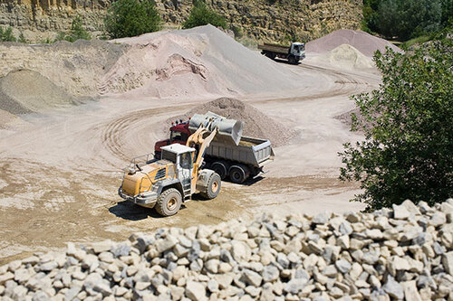 Bagger belädt im Steinbruch einen LKW