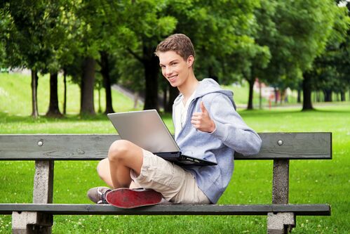 Bursche mit Laptop im Park