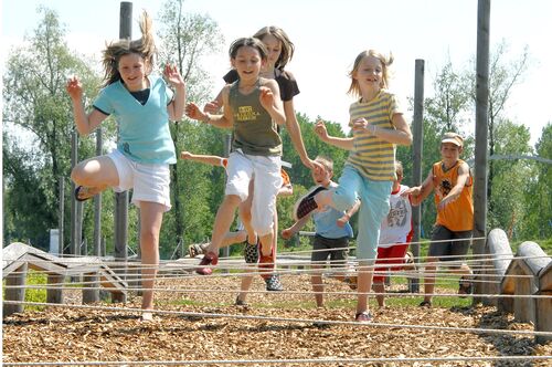 Kinder laufen am Spielplatz