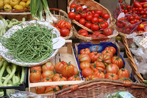 Geflochtene Körbe mit Gemüse wie z. B. Tomaten, große Fleischtomaten, Fisolen, Kartoffeln und Jungzwiebel
