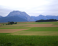 Acker- und Wiesenlandschaft mit Gebierge im Hintergrund 