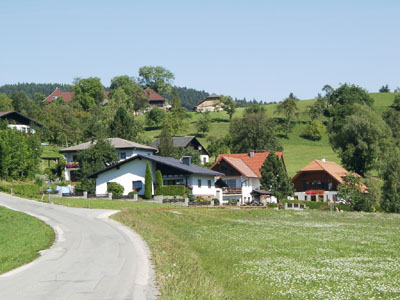 Typische Siedlungsstruktur aus neueren Wohnbauten und Gebäuden traditionellen Stils an den Unterhängen der Raumeinheit (bei Viechtwang im Westteil des AKF)