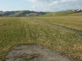 Extrem ausgeräumte Intensivwiesenlandschaft am kanalisierten Sandbach in Bruck bei Eschenau; hinten intensiv genutzte Sauwald-Abhänge.