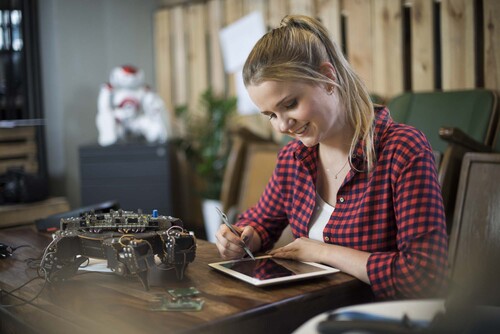 Junge Frau bei der Arbeit an einem elektronischen Gerät