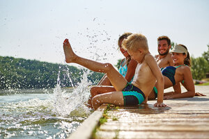 Familie und Kinder plantschen im Wasser