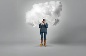 Landwirtin steht vor grauem Hintergrund und hält ein Smartphone vor ihr Gesicht. Der Kopf ist durch eine weiße Wolke verdeckt.