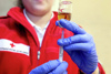 Santitäterin vom Roten Kreuz zieht eine Spritze mit einem Medikament auf