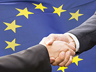 Handschlag vor EU-Flagge