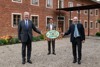 NÖ-LR Martin Eichtinger, Lukas Hader und LR Max Hiegelsberger stehen vor einem Haus mit Blumen davor und halten gemeinsam eine Zaun-Plakette in der Hand mit der Aufschrift „Natur im Garten“.