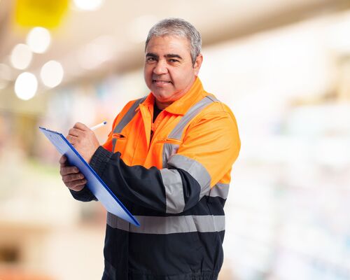  Mann in Arbeitskleidung schreib auf eine Schreibunterlage