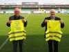 Karl Wagner und Thomas Dim präsentieren die SV Ried Warnwesten auf einem Fußballfeld