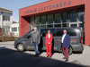 Johann Würzburger, Hilde Prandner und Erich Wahl mit einem Transporter-Bus vor einem Gebäude mit Aufschrift Forum Luftenberg