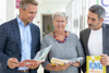 LR Dr. Wolfgang Hattmannsdorfer, Mag.a Gabriele Müller und Sefa Yetkin stehen nebeneinander im Gangbereich des OÖ. Presseclubs, sie halten Kinderbücher in den Händen.