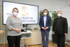 Silvia Breitwieser, Landesrat Wolfgang Hattmannsdorfer und Generalvikar Severin Lederhilger, alle mit FFP2-Maske, stehen nebeneinander in einem Büro vor einem Bildschirm, auf dem der Text 142 Telefonseelsorge aufscheint