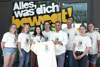 Sofia Friedinger, Viktoria Wahlmüller, Lenja Schaubmayer, Jakob Kleschpis, LR Wolfgang Hattmannsdorfer, Samuel Böck (JugendService), Emilia Berlinger und Lukas Nopp stehen nebeneinander vor dem JugendService des Landes OÖ; sie halten ein T-Shirt, auf dem ein Mikrofon mit der Aufschrift „Team OÖ“ zu sehen ist, in ihren Händen.