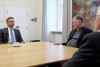 Landesrat Wolfgang Hattmannsdorfer, Bischof Manfred Scheuer und Franz Kehrer sitzen im Halbkreis um einen Konferenztisch, im Hintergrund an der Wand ein Gemälde 