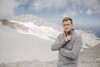 LR Stefan Kaineder steht auf einem verschneiten Bergmassiv 