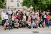 Landesrat Stefan Kaineder (links im Bild), steht mit Schülerinnen und Schülern der Volksschule Windischgarsten, Lehrerinnen sowie Klimabündnis-Geschäftsführer Mag. Norbert Rainer (rechts hinten) und Sonja Kirner vom OÖVV (vorne links) im Freien vor einem Gebäude. 