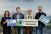 Ines Gruber, Umwelt- und Klima-Landesrat Stefan Kaineder, Bürgermeisterin Katharina Seebacher und Klimabündnis OÖ Geschäftsführer Norbert Rainer stehen in einer Reihe nebeneinander und halten Klimabündnis-Plakate in den Händen.