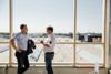 Landesrat Stefan Kaineder und Markus Hargassner stehend im Gespräch einander zugewandt, im Hintergrund Flachdach eines Betriebsgebäudes