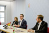 Veronika Marhold, LL.B., Landesrat Stefan Kaineder und Mag. Gregor Schamschula sitzen nebeneinander an einem Konferenztisch, auf dem Mikrofone stehen