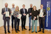 Mag. Johannes Huber, Reinhard Pribil, Mag.a Kristina Lisa Haselgrübler, Landesrat Stefan Kaineder, Norbert Rainer, DIin Sarah Siemers und Mag. Michael Hag stehen nebeneinander in einem Raum, im Hintergrund ein Rollup der Raiffeisenbank 