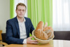 Landesrat Stefan Kaineder mit einem vollen Brotkorb