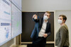 Landesrat Stefan Kaineder mit Abteilungsleiterin DI Daniela König, MBA, beide tragen FFP2 Masken, Kaineder zeigt auf eine digitale Karte an der Wand, im Hintergrund Büroräumlichkeiten