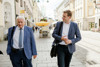 Dr. Friedrich Schneider und Landesrat Stefan Kaineder gehend im Gespräch auf der Linzer Landstraße 