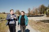 Landesrat Stefan Kaineder und DI Franz Gillinger (Chef des Gewässerbezirkes Linz und Wasserbauexperte)  gehen nebeneinander auf einem Weg und reden miteinander.