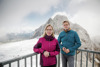 Leonore Gewessler und Landesrat Stefan Kaineder stehen hintereinander am Geländer einer Aussichtsplattform, im Hintergrund Gletscher, Felsen