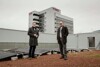 Landesrat Stefan Kaineder mit Dr. Christian Jungwirth vor dem neuen Sonnenkraftwerk am Dach des Linzer BFI