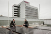 Landesrat Stefan Kaineder und Dr. Christian Jungwirth betrachten das  Sonnenkraftwerk am Dach des Linzer BFI aus der Nähe