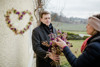 Landesrat Stefan Kaineder mit einen Blumenstraß aus getrockneten Blumen im Gespräch mit der Blumenhändlerin